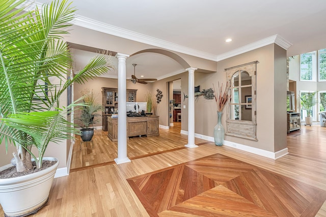 foyer with ornamental molding, decorative columns, light hardwood / wood-style floors, and ceiling fan