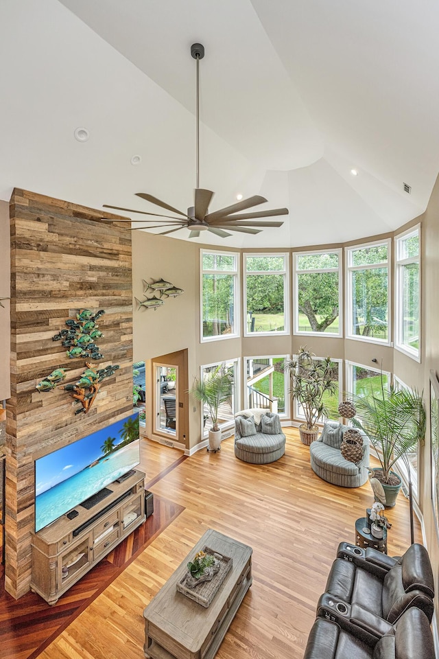 living room with wood-type flooring and high vaulted ceiling