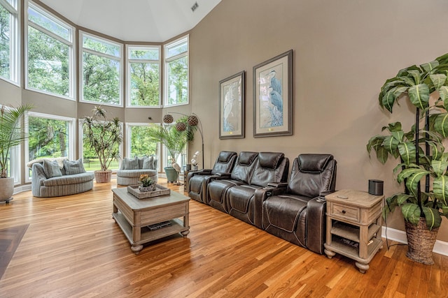 living room featuring a towering ceiling and light wood-type flooring