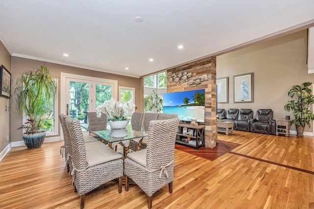 dining area with ornamental molding and light hardwood / wood-style flooring