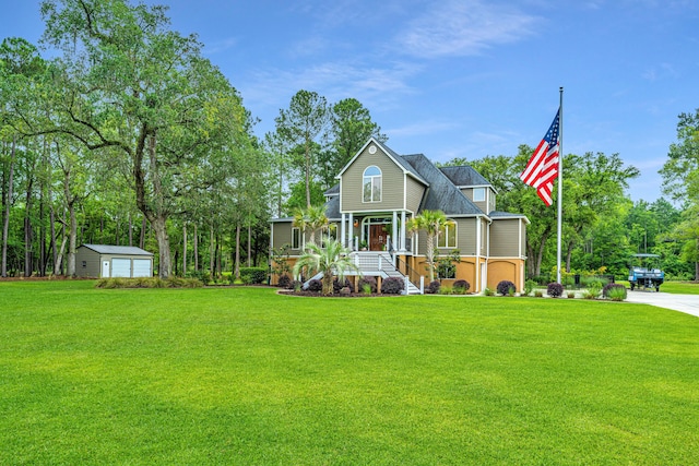 view of front of property featuring a garage, an outbuilding, covered porch, and a front lawn