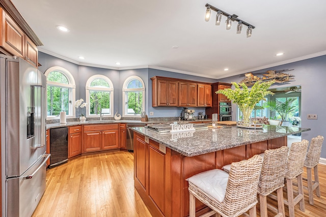 kitchen featuring sink, dark stone counters, a kitchen breakfast bar, a kitchen island, and stainless steel appliances