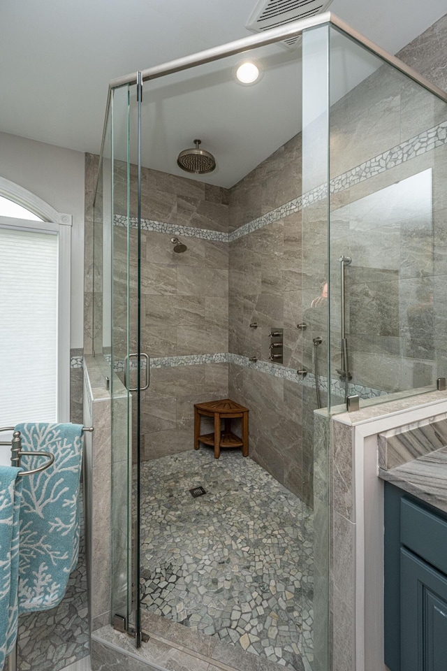 bathroom featuring walk in shower and vanity