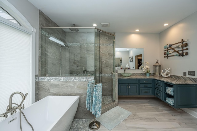 bathroom with vanity and shower with separate bathtub