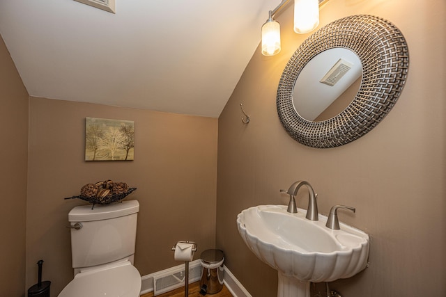 bathroom featuring sink, vaulted ceiling, and toilet