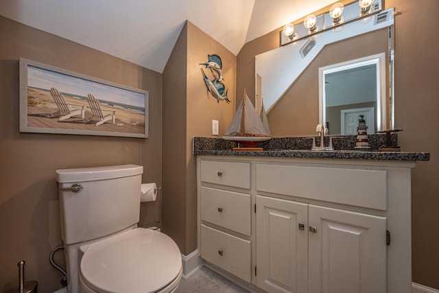 bathroom with vaulted ceiling, vanity, and toilet