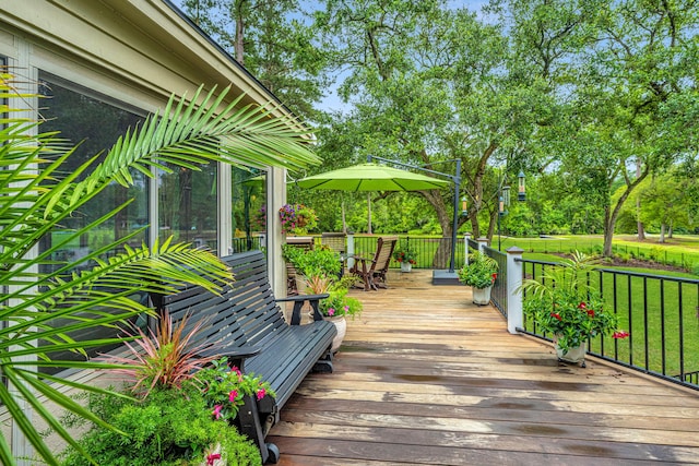 wooden terrace with a yard and a sunroom