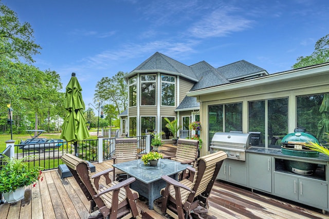 wooden terrace with an outdoor kitchen, grilling area, and a sunroom