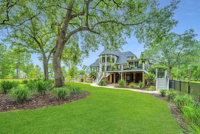 back of property featuring a wooden deck, a yard, and a sunroom