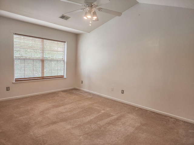 spare room with vaulted ceiling, light carpet, and ceiling fan