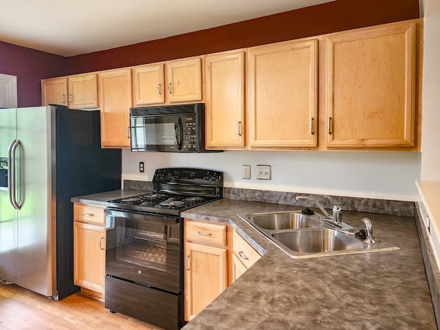 kitchen with black appliances, sink, light hardwood / wood-style flooring, and light brown cabinets