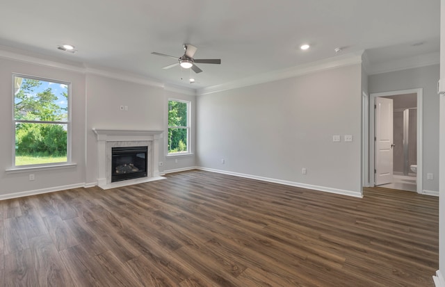 unfurnished living room featuring ornamental molding, dark hardwood / wood-style floors, a high end fireplace, and ceiling fan