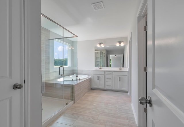 bathroom featuring independent shower and bath and vanity