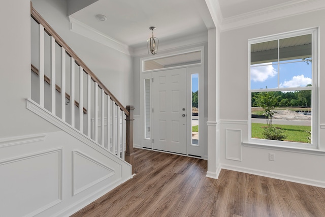 entrance foyer featuring hardwood / wood-style flooring, plenty of natural light, and ornamental molding