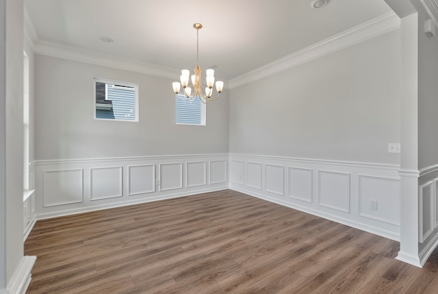 empty room with crown molding, dark hardwood / wood-style flooring, and a chandelier