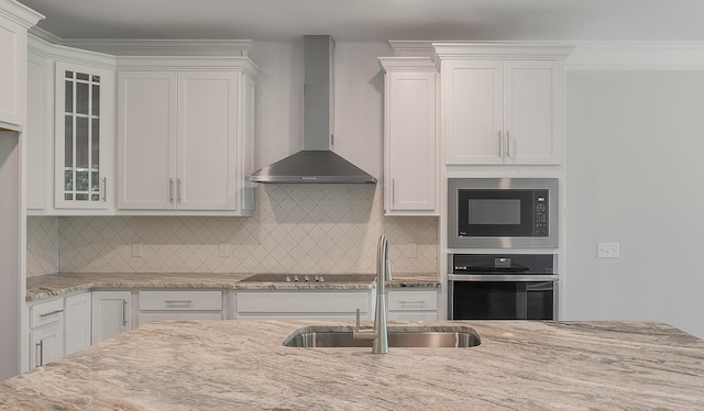 kitchen with white cabinetry, wall chimney exhaust hood, oven, black electric stovetop, and sink