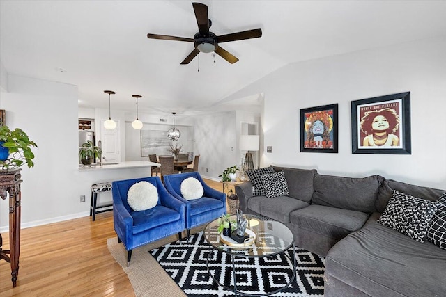 living room with ceiling fan, lofted ceiling, and light wood-type flooring