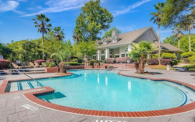 view of pool featuring a hot tub and a patio area