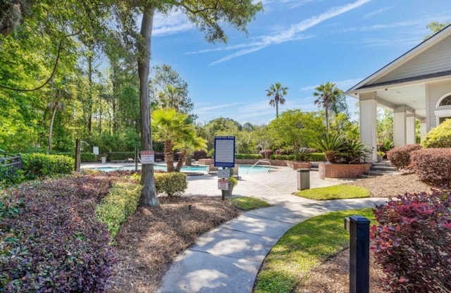 surrounding community featuring a patio and a pool with hot tub