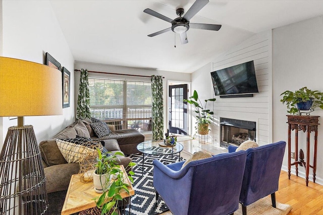 living room with lofted ceiling, hardwood / wood-style flooring, a fireplace, and ceiling fan