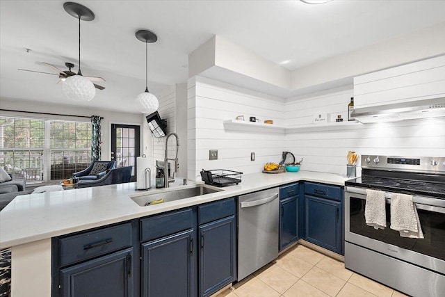 kitchen with kitchen peninsula, hanging light fixtures, sink, blue cabinets, and appliances with stainless steel finishes