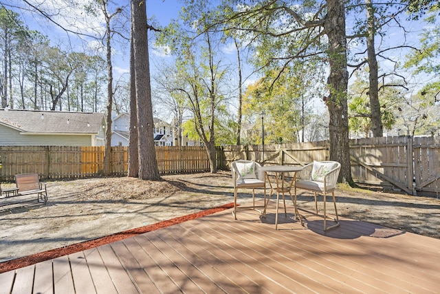 wooden terrace featuring a fenced backyard and outdoor dining space