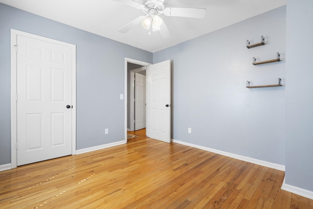 unfurnished bedroom featuring light wood-style flooring, baseboards, and a ceiling fan