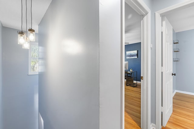 hall featuring baseboards and wood finished floors