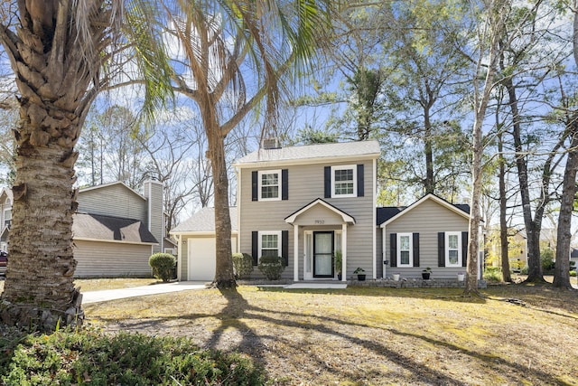 colonial inspired home with a garage, driveway, a chimney, and a front lawn