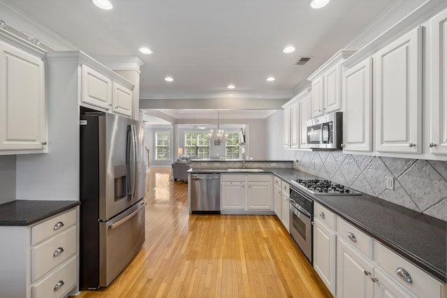 167 Palm Cove Way, Mount Pleasant, SC 29466 - kitchen with appliances with stainless steel finishes, crown molding, white cabinetry, light wood-type flooring, and a peninsula