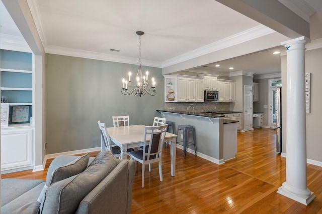 167 Palm Cove Way, Mount Pleasant, SC 29466 - dining room with light wood-style floors, a chandelier, ornate columns, ornamental molding, and recessed lighting