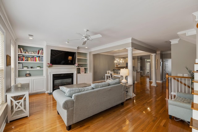 167 Palm Cove Way, Mount Pleasant, SC 29466 - living room featuring ceiling fan, crown molding, ornate columns, light wood finished floors, and a glass covered fireplace