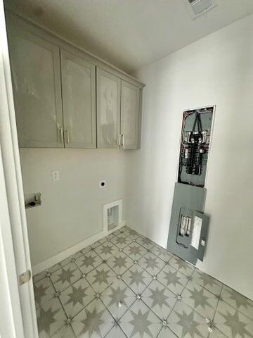 washroom featuring cabinet space, visible vents, light floors, and hookup for an electric dryer