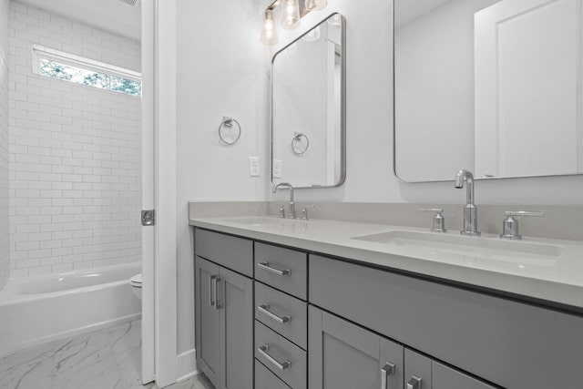 full bathroom featuring marble finish floor, double vanity, a sink, and toilet