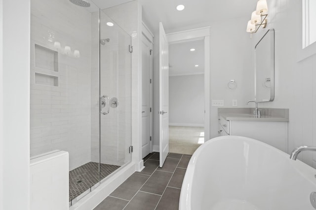 full bathroom featuring a stall shower, baseboards, tile patterned flooring, vanity, and a freestanding tub