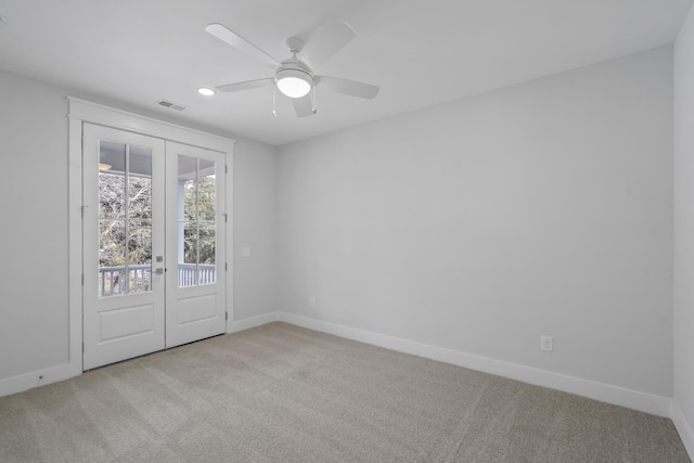 spare room featuring carpet floors, baseboards, visible vents, and a ceiling fan