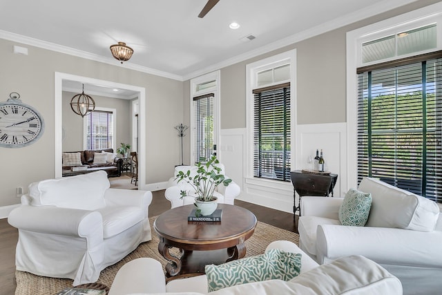 2072 Amenity Park Dr, Mount Pleasant, SC 29466 - living area with dark wood-type flooring, ceiling fan, ornamental molding, a wainscoted wall, and a chandelier