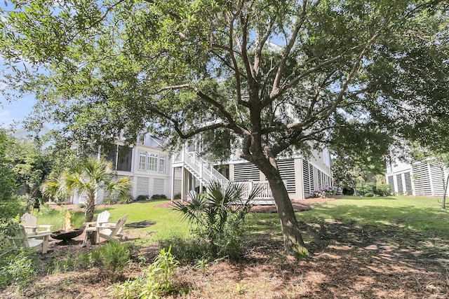 2072 Amenity Park Dr, Mount Pleasant, SC 29466 - view of green lawn featuring a fire pit, stairway, and a sunroom