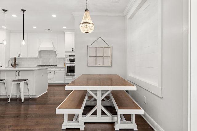 dining area with dark hardwood / wood-style floors, crown molding, and a notable chandelier