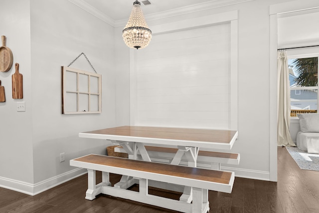 dining room with dark hardwood / wood-style floors, crown molding, and an inviting chandelier