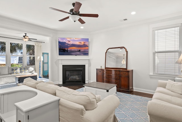 living room with ceiling fan, ornamental molding, a healthy amount of sunlight, and hardwood / wood-style flooring