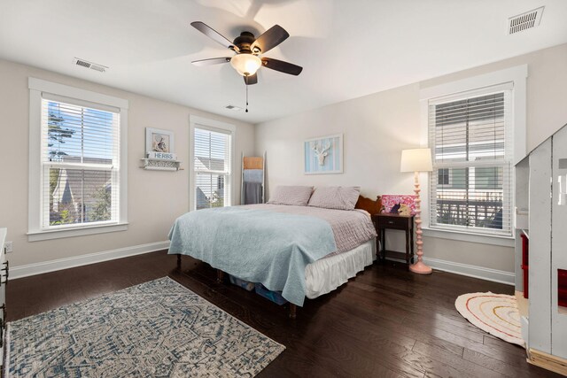 bedroom with dark hardwood / wood-style floors, ceiling fan, and multiple windows