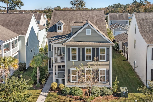 back of house with a lawn and a balcony