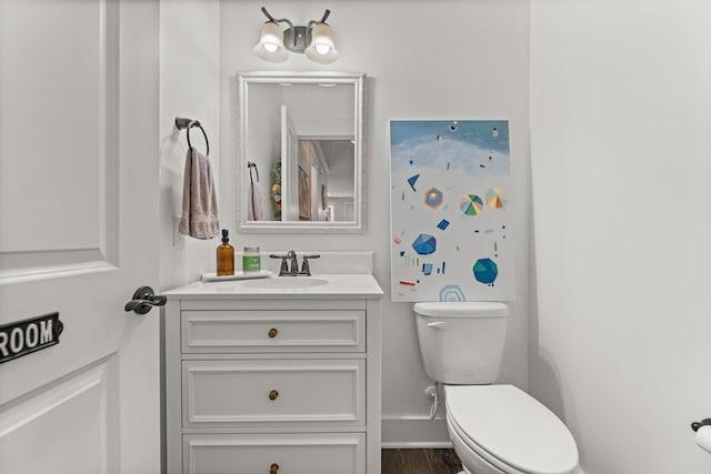 bathroom featuring vanity, wood-type flooring, and toilet