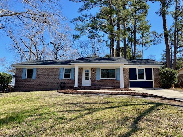 single story home with a front lawn, concrete driveway, and brick siding