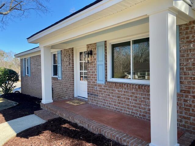 entrance to property featuring brick siding and a porch