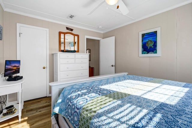 bedroom with hardwood / wood-style floors, ornamental molding, and ceiling fan