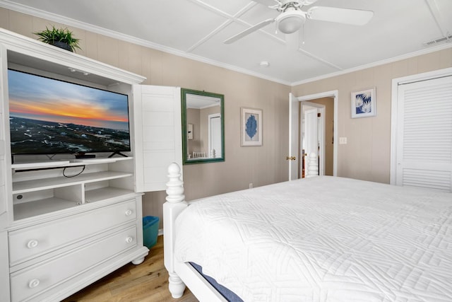 bedroom featuring crown molding, ceiling fan, wood-type flooring, and a closet