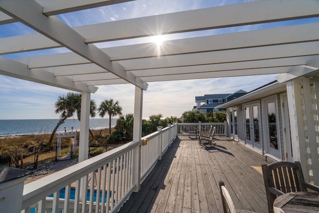 deck with a water view, a pergola, and french doors