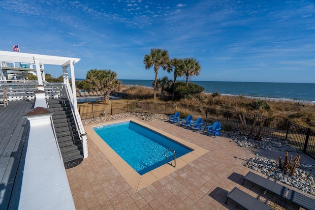 view of pool with a patio and a water view